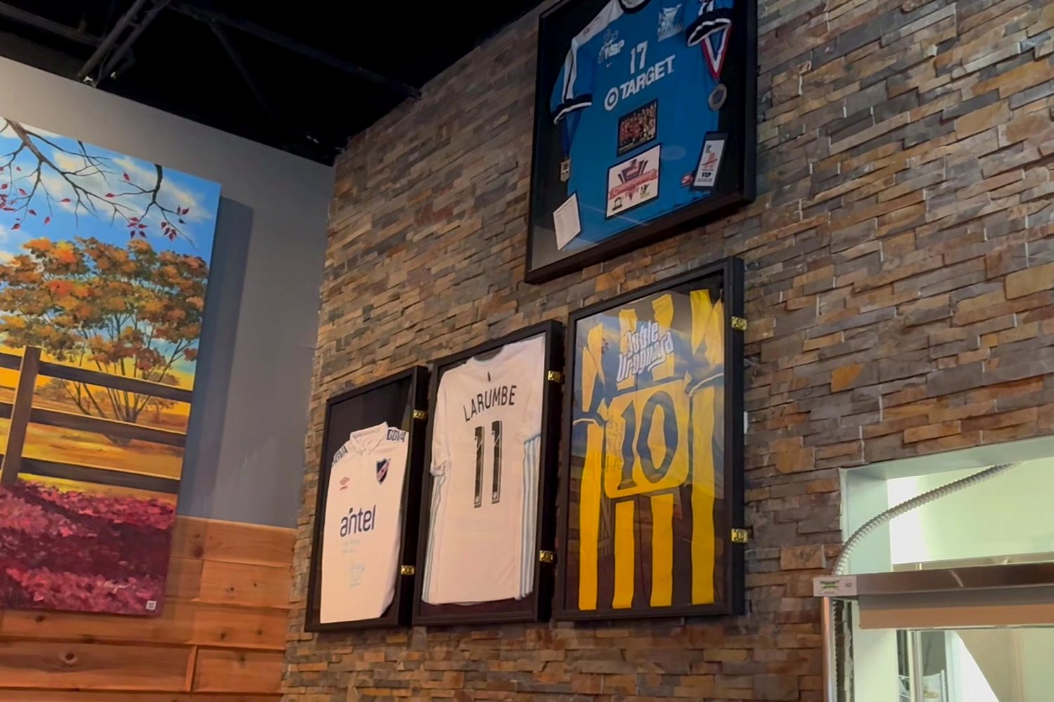 Framed soccer jerseys on our stone wall, including one with Daniel Larumbe’s name